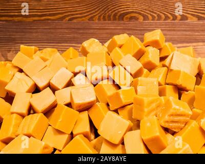 Une pile de bonbons caramel en orange sous forme de cubes. Un arrière-plan abstrait de délicieux cadeaux. Banque D'Images