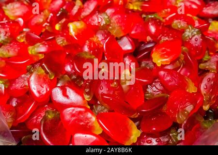 Tranches rouges vives de bonbons à mâcher marmelade. Belle délicatesse douce de jus de fruits gélifiés. Arrière-plan coloré et lumineux. Des friandises à refus aléatoire. Banque D'Images