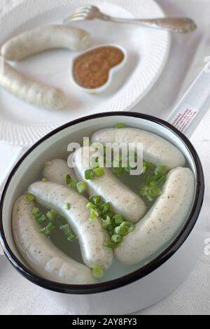 Saucisses de veau de Munich dans une casserole avec oignons de printemps (weisswurst) Banque D'Images