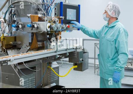 L'usine de l'industrie pharmacie travailleur homme avec des vêtements dans des conditions de travail Banque D'Images