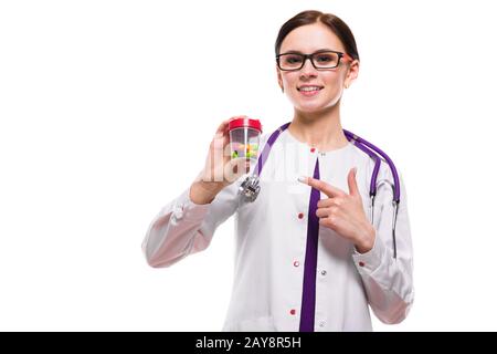 Belle jeune femme médecin holding bouteille de pilules dans ses mains sur fond blanc Banque D'Images