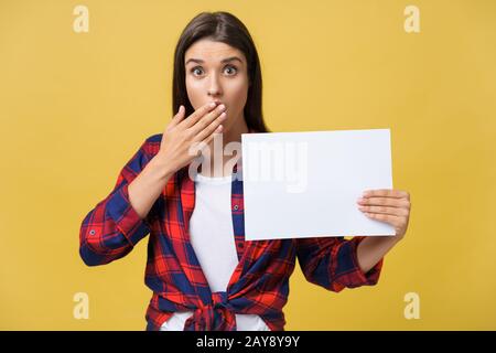 L'étonnement ou surpris femelle avec panneau blanc et vide, isolé sur fond jaune. Banque D'Images