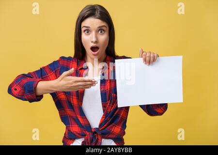 L'étonnement ou surpris femelle avec panneau blanc et vide, isolé sur fond jaune. Banque D'Images