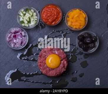 Steak tartare d'œufs sur ardoise Banque D'Images