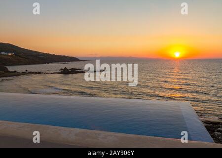 Piscine surplombant la mer au coucher du soleil à Pomos, Chypre Banque D'Images