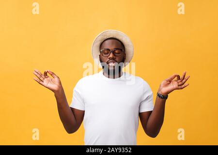 Gros plan portrait de heureux beau, jeune homme en mode yoga de méditation, isolé sur fond jaune. Techniques de soulagement de la contrainte c Banque D'Images