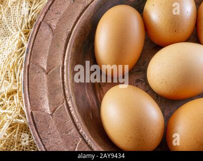 Œufs en plaque de cuivre sur une toile à rackCloth brune (burlap) - démonstration de concept de nourriture biologique traditionnelle Banque D'Images