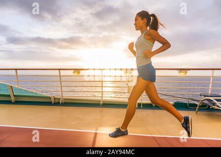 Les passagers du bateau de croisière font du jogging le matin sur des pistes de course sur la terrasse avec soleil au lever du soleil. Femme touriste profitant de l'entraînement de forme physique pendant des vacances de voyage dans les Caraïbes. Banque D'Images