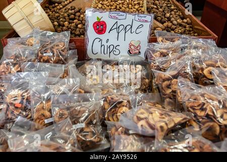 Paquet de chips de pomme faites à la main, avec ou sans cannelle, sur le marché local. Frites emballées dans des sacs en plastique. Signe de prix écrit à la main. Aliments biologiques. Banque D'Images