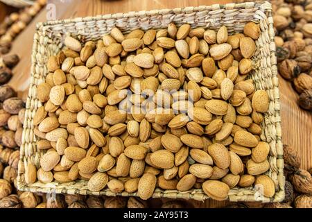 Gros plan sur un panier d'amandes fraîches pelées en vente sur le marché alimentaire local. Autres fruits secs dans le fond flou. Des collations saines. Banque D'Images