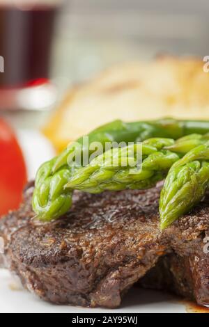 Bifteck de boeuf et asperges vertes sur une plaque Banque D'Images