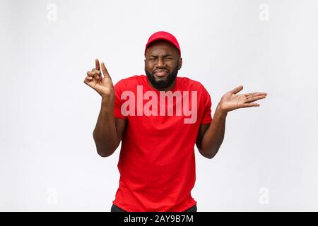 Concept de livraison - Portrait d'un Homme de livraison africain Sérieux montrant une expression ridicule agressive et mécontent. Isolé o Banque D'Images