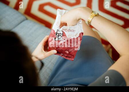 Paris, France - 1 août 2019: Femme prenant du sac de papier à viande KFC viande fraîche délicieuse viande - vue au-dessus de la table de séjour Banque D'Images