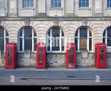 une ligne de quatre boîtes téléphoniques rouges britanniques traditionnelles à l'extérieur d'un ancien bâtiment de poste à blackpool Banque D'Images