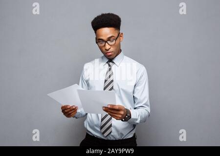 Concept d'affaires - handsome young african american businessman reading concentré sur le document papier. Banque D'Images
