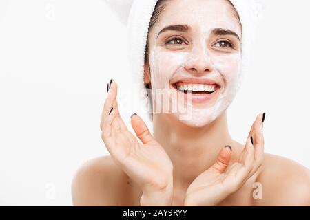 Soins De La Peau - concept beauté Belle Caucasian Woman Face Portrait Masque crème appliquer sur la peau du visage de son fond blanc. Banque D'Images