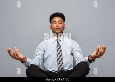 Concept d'affaires - portrait of african american businessman doing Meditation et Yoga yoga en avant de travailler. Banque D'Images