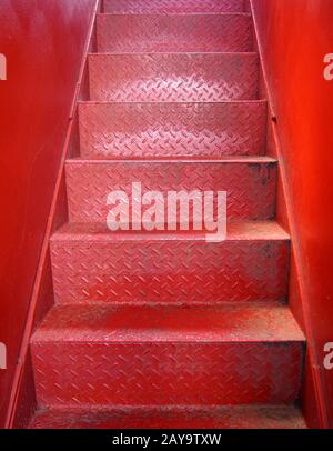 escalier en métal peint rouge vif avec marches en tôle d'acier avec surface texturée et murs Banque D'Images