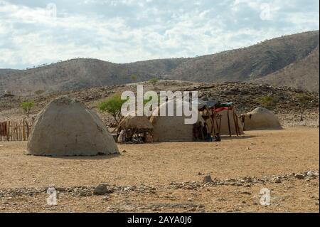 Vue sur les maisons Himba en forme de cône, faites de boue, de fumier de vache et de mopane, dans le Damaraland du nord-ouest de la Namibie. Banque D'Images