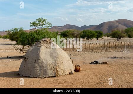 Vue sur une maison Himba en forme de cône, faite de boue, de fumier de vache et de mopane, dans le Damaraland du nord-ouest de la Namibie. Banque D'Images