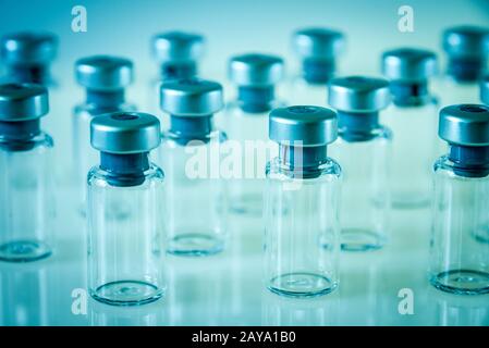 Flacons en verre de vaccin sur fond bleu Banque D'Images