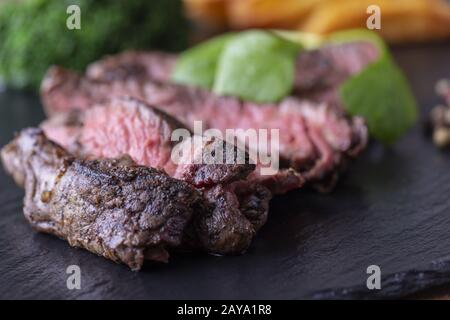 Tranches de steak grillé sur ardoise Banque D'Images