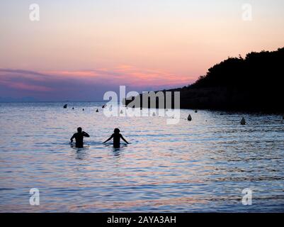 coucher de soleil à minorque avec ciel violet et orange avec un couple en silhouette de mer Banque D'Images