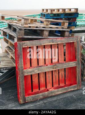 une pile de palettes en bois anciennes empilées à l'extérieur peintes en différentes couleurs Banque D'Images