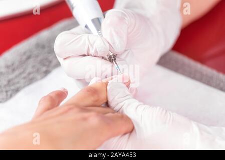 Procédé de manucure professionnel, nettoyage des ongles avec une fraise de manucure, au salon de la béuticienne. Banque D'Images