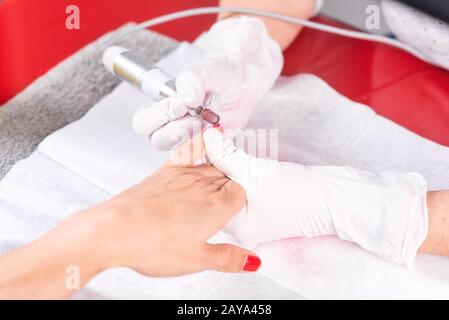 Procédé de manucure professionnel, nettoyage des ongles avec une fraise de manucure, au salon de la béuticienne. Banque D'Images