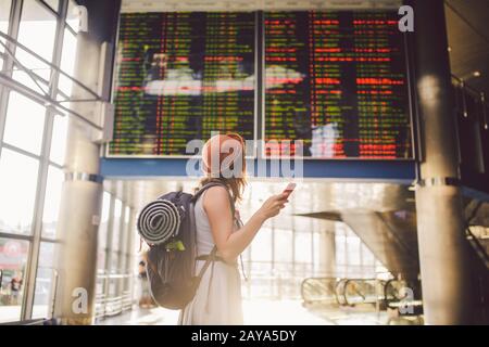 Voyage à thème et tranosport. Belle jeune femme caucasienne en robe et sac à dos debout à l'intérieur de la gare ou terminal loo Banque D'Images