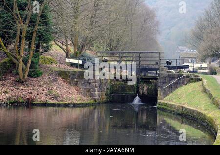 vieilles portes en bois sur le canal de rochdale près du pont de hebden avec paysage boisé en hiver Banque D'Images