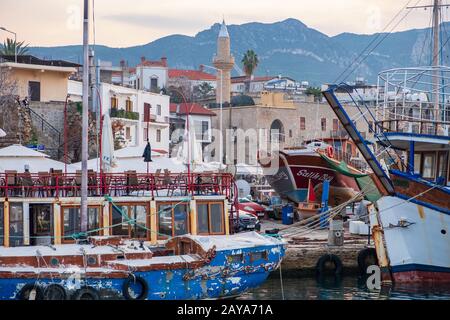 Belle vue sur le vieux port de Kyrenia avec des bateaux, des bâtiments et les montagnes à la distance en fin d'après-midi magnifique Banque D'Images