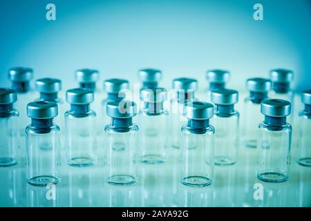 Flacons en verre de vaccin sur fond bleu Banque D'Images