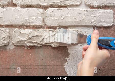 Plâtrier travaille manuellement avec une spatule et lisser le plâtre sur le mur Banque D'Images