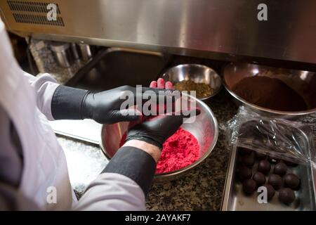 Chocolats de cuisine à thème truffe. Gros plan la jeune femme caucasienne et l'homme cuisinent avec tatouage et en uniforme prépare, fait ro Banque D'Images
