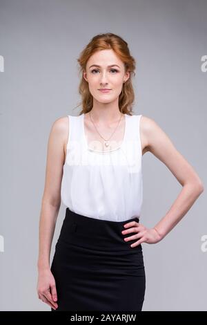 Gros plan portrait jeune, belle femme d'affaires, étudiant avec lred, cheveux frisés et freckles sur le visage sur fond gris dans les s Banque D'Images