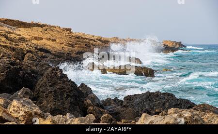 Les vagues de la mer s'écrasent sur les rochers de la plage Apostolos Andreas à Karpasia, Chypre Banque D'Images