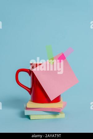 Vue avant tasse à café tasse boisson chaude thé couleur collant note bannières empilées pads couché magnifique arrière-plan pastel. Abstra Banque D'Images