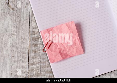 Papier à note froissé et un carnet placé au-dessus de la table en bois. Drap froissé plus bâton fixe à l'arrière-plan classique à tilte Banque D'Images