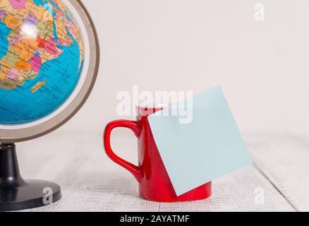 Vue avant gros plan globe carte monde terre café tasse collant note couché rétro vintage rustique vieux fond de table. Un déig abstrait Banque D'Images