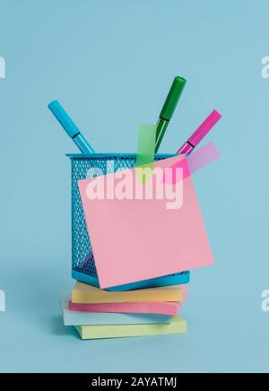 Vue avant des bannières en forme de pense-bête colorées empilent le porte-stylos en métal couché sur un magnifique arrière-plan pastel. Texte vide impo. Future Banque D'Images