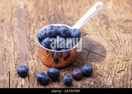 Bleuets dans une casserole sur bois Banque D'Images