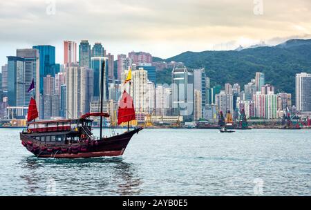 Jonque traditionnelle Chinoise en face de Hong Kong skyline Banque D'Images