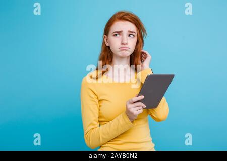 Gros plan Portrait jeune beau beau gingembre tendre redhair fille heureux souriant sur table numérique avec quelque chose de gueule. Bl Banque D'Images