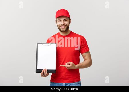 Homme de livraison en uniforme rouge contenant du papier blanc vide isolé sur fond blanc. Copier l'annonce d'espace. Place pour te Banque D'Images