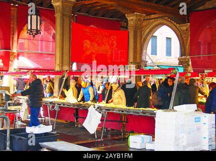 les poissonniers et les gens font du shopping sur le marché historique du poisson dans le quartier du rialto à venise Banque D'Images