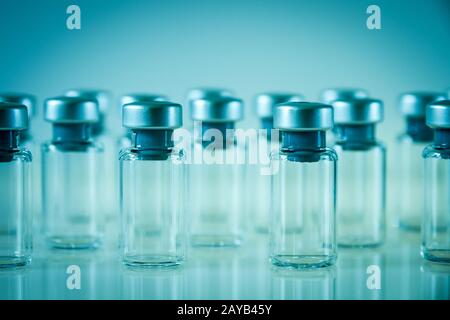 Flacons en verre de vaccin sur fond bleu Banque D'Images