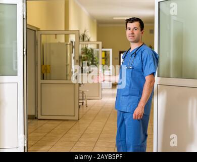 Médecin d'âge moyen invitant les patients à la clinique ou à l'hôpital Banque D'Images
