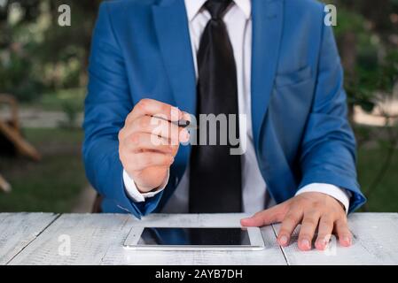 Homme d'affaires tient le stylo et pointe dans l'espace de copie. Homme avec le dessus de tour et le stylo dans la main. Concept d'affaires avec homme dans la suite W Banque D'Images